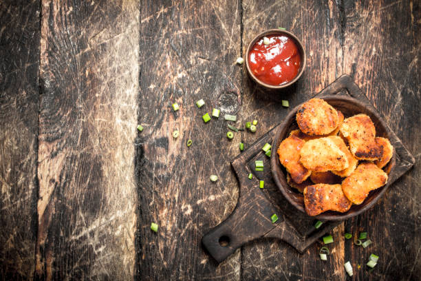 Chicken nuggets in a bowl with tomato sauce. Chicken nuggets in a bowl with tomato sauce. On a wooden background. heathy snack stock pictures, royalty-free photos & images