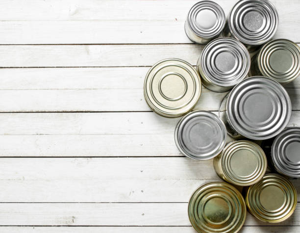 Tin cans with food. Tin cans with food. On white wooden table. canned food stock pictures, royalty-free photos & images