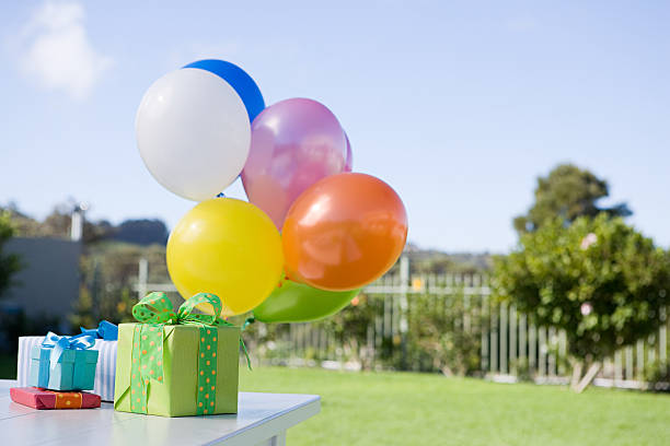 balloons and birthday presents on table in garden - birthday present 뉴스 사진 이미지