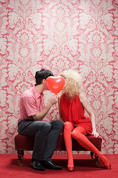 пара за шар в форме сердца - love valentines day heart shape kissing стоковые фото и изображения