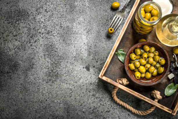 istock Olive oil with pickled olives on an old tray. 902882862