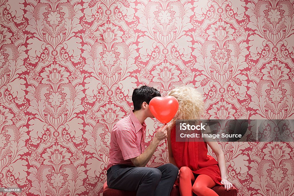Couple behind heart shaped balloon  Valentine's Day - Holiday Stock Photo