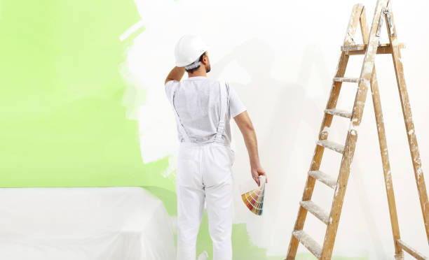 istock painter man at work with color swatches samples, wall painting green color ecological concept, web banner template 902886800