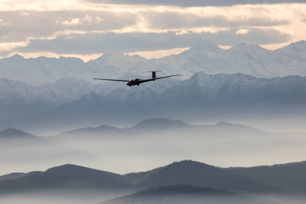 istock Glider over foggy mountain silhouette landscape 902892690