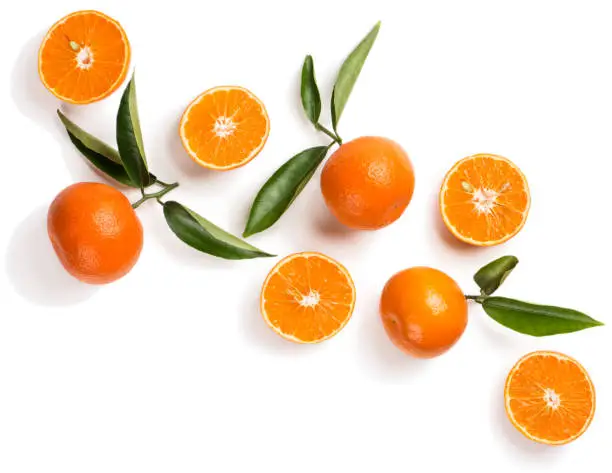 "nTop view of halves and wholes of tangerine fruits with leaves isolated on white background.