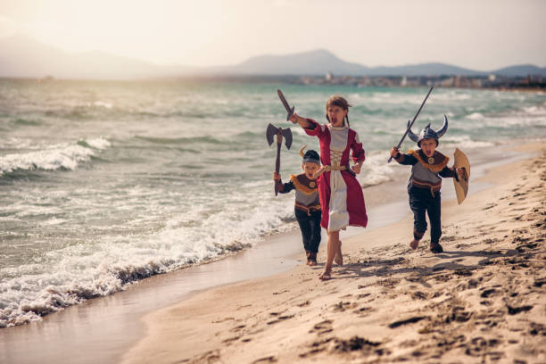 istock Kids vikings charging thrrough the beach 902894244