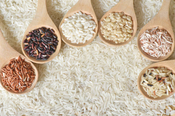 istock Top view different rice on wooden scoop with jasmine rice background, Various rice organic on wooden spoon collection 902894252