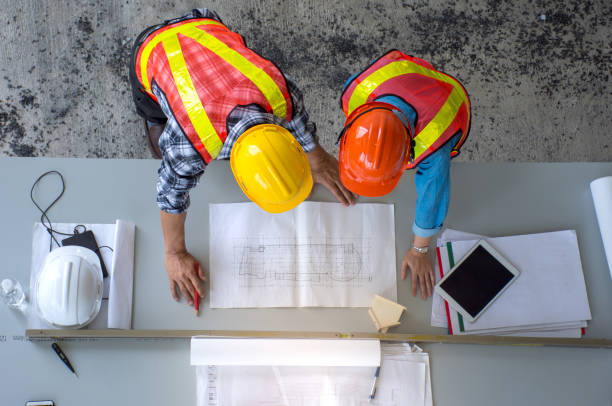 istock Top view of group of engineering team is meeting, planning construction work,looking paper plans at construction site,overhead view 902898076