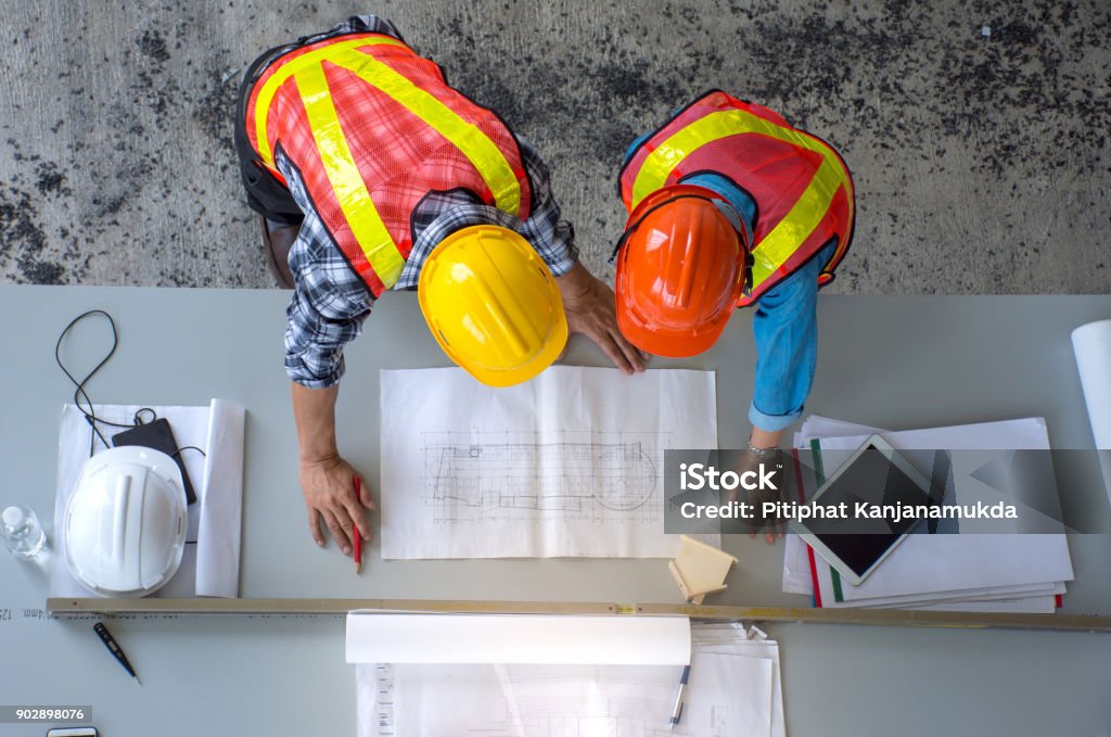 Top view of group of engineering team is meeting, planning construction work,looking paper plans at construction site,overhead view Top view of group of engineering team is meeting, planning construction work,looking paper plans at construction site,overhead view,Concept for team work Advice Stock Photo