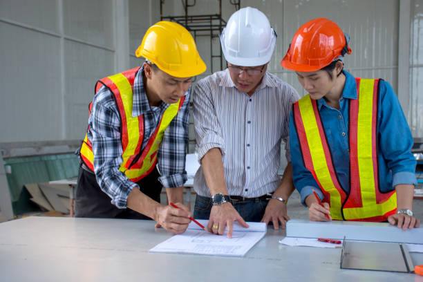 istock Group of engineering team is meeting, planning construction work,looking paper plans at construction site,overhead view 902898100