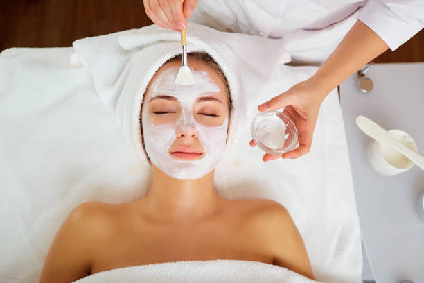 woman in mask on face in spa salon - make up cosmetics women make up brush imagens e fotografias de stock