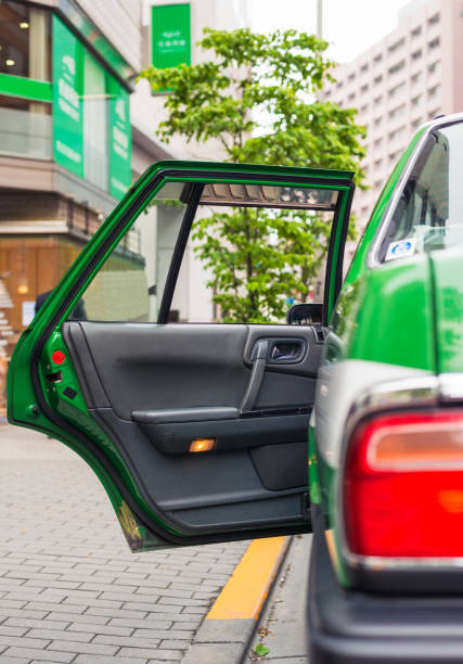 Available taxi in Tokyo, Japan A taxi's passenger door open by the sidewalk in Ginza, Tokyo. car back open stock pictures, royalty-free photos & images