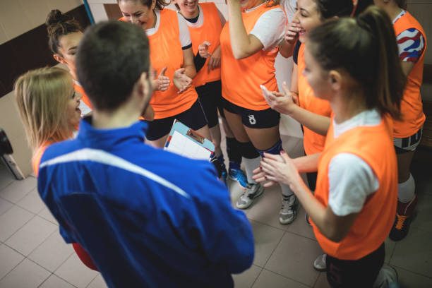 istock Coach talking to female volleyball team 902906924