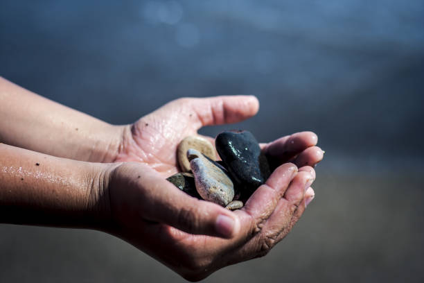 istock A hand holding sea glass pebbles. 902909774