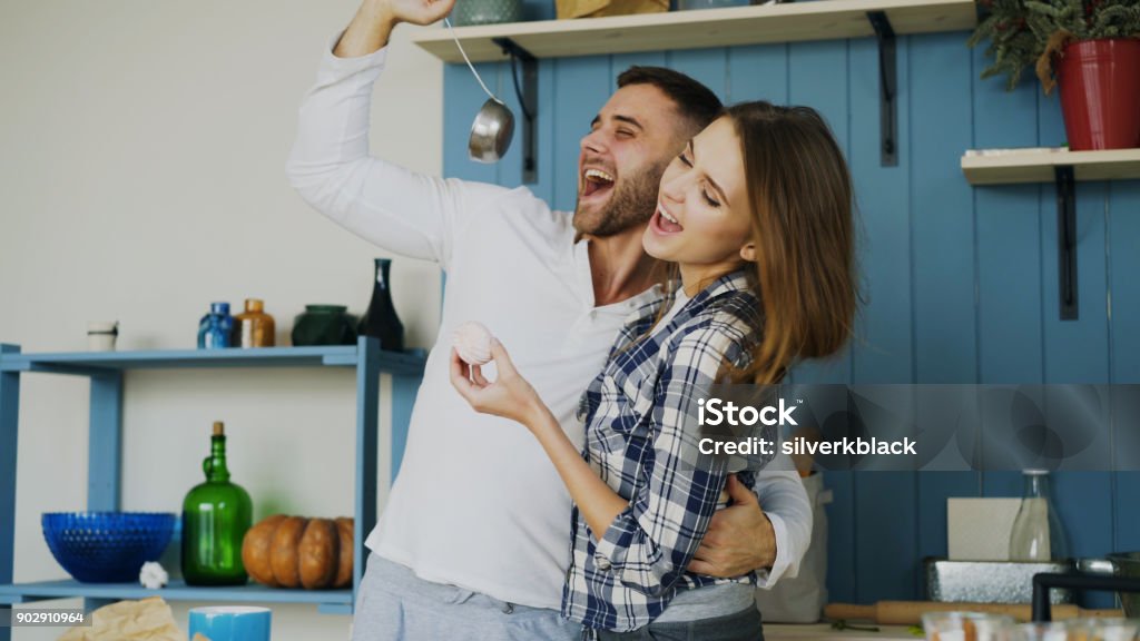 Freudige paar hat Spaß am tanzen und singen in der Küche zu Hause am Morgen - Lizenzfrei Junges Paar Stock-Foto