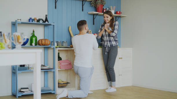 istock Young man making proposal to his girlfriend in the kitchen at home 902914196
