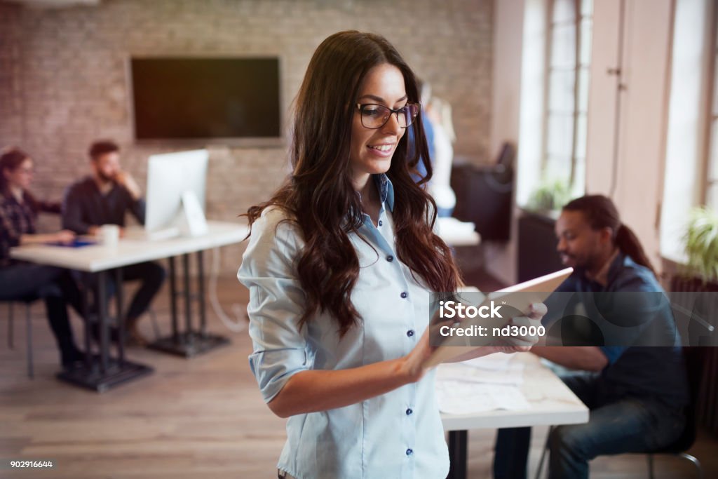 Portrait of young beautiful female designer using tablet Portrait of young beautiful female designer using tablet in office Digitally Generated Image Stock Photo