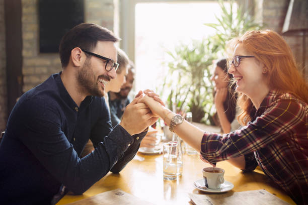 istock Handsome man flirting with cute woman in restaurant 902916996