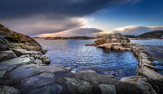 Old Stone Pier in the sea in Helleviga recreation area, between Kristiansand and Sogne in South Norway. Evening light, blue hour.