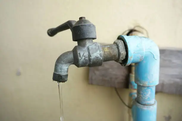 A photo of Chrome faucet and water pipeline with blue pvc pipe, close up