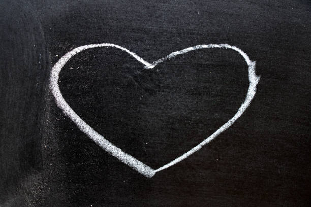 istock White coloe chalk drawing as heart shape on blackboard background with copy space 902944226
