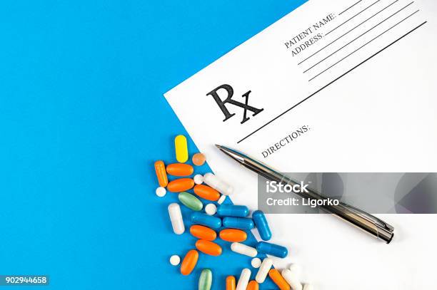 Prescription Form With Pills And Pen With On Blue Top View Medical Concept Stock Photo - Download Image Now