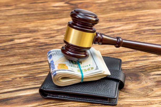 istock Judges hammer with folded dollars and wallet on the table. 902945462