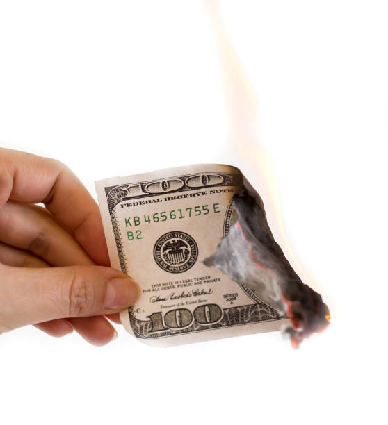 istock a hundred dollars burn in a fire on a white background 902950072
