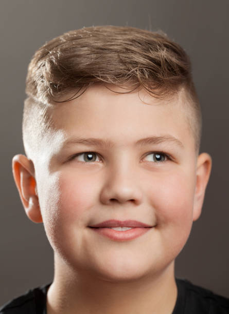 istock Smiling Teenager boy on grey background 902953724