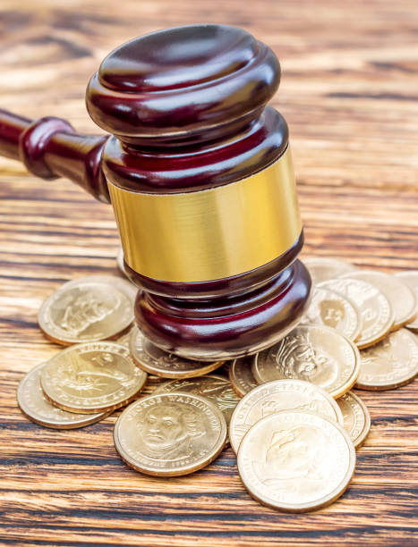 istock Judge's gavel with coins on the table. Close up. 902954436