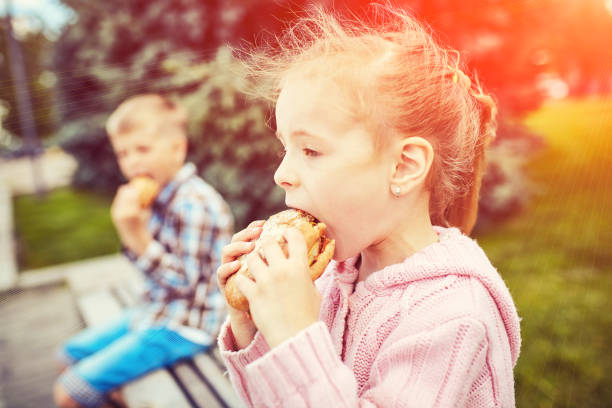 istock Children on in the park eating a burger 902958336
