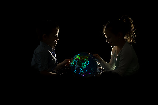 Children looking at glowing globe of world map. Standard Map of World