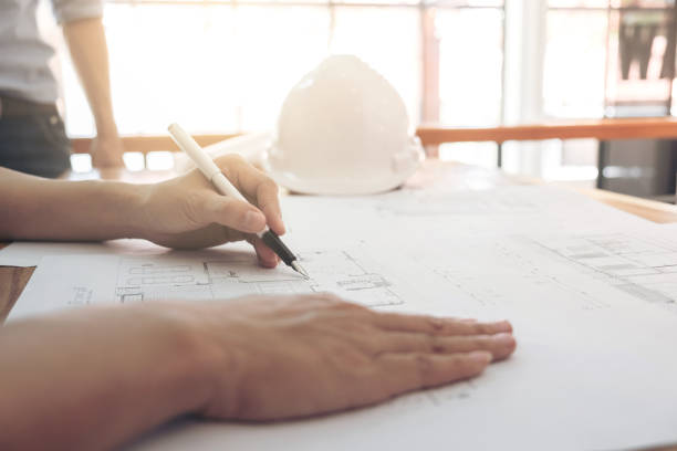 istock Image of engineer or architectural project, Close up of Architects engineer's hands drawing plan on BluePrint with Engineering tools on workplace, Construction concept 902962370