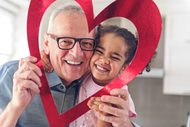 Valentine's Day Grandparents playing with a heart frame shape granddaughter photos stock pictures, royalty-free photos & images