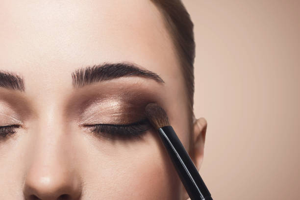 istock Make-up artist apply eyeshadow with brush, beauty 902969456