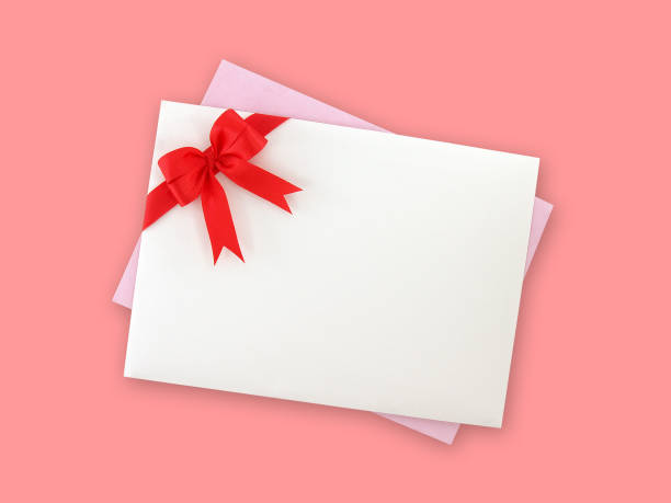 istock white envelope with red ribbon bow and light purple greeting card isolated on pink background 902969776