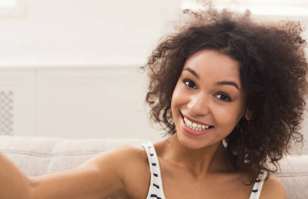 istock Cute smiling african-american girl making selfie 902970476