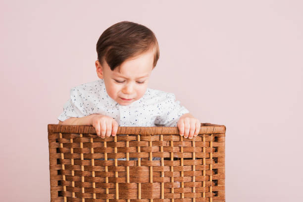 istock Cute child crying in a laundry basket. 902970550