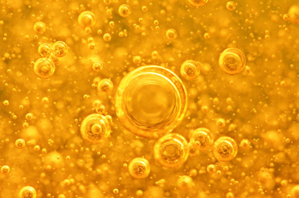 Golden background with big and small gold bubbles oil inside a gold liquid.