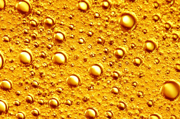 Golden background with big and small gold bubbles oil inside a gold liquid.