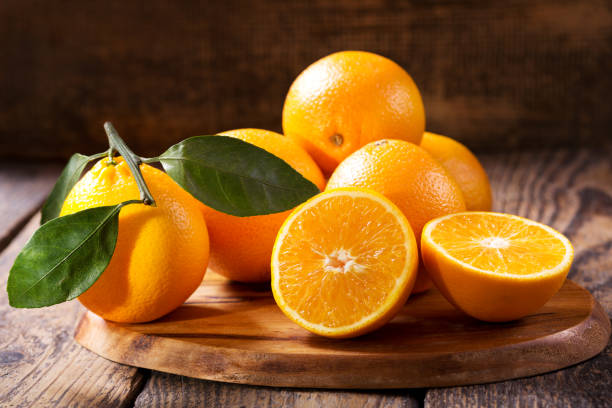 istock fresh orange fruits with leaves 902979518