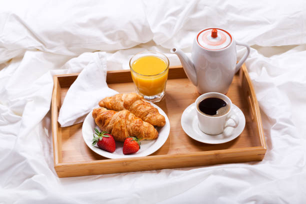 istock breakfast tray with coffee and croissants in bed 902979586