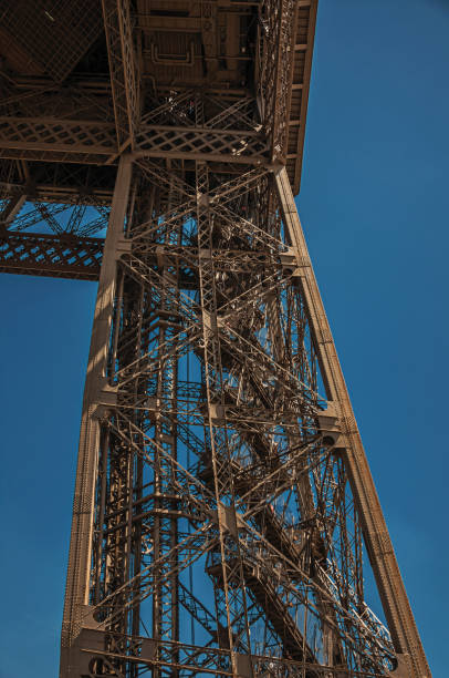 istock View of one leg’s iron structure of the Eiffel Tower, with sunny blue sky in Paris. 902983806