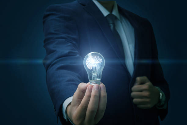 istock Businessman hand holding a burning light bulb. 902986698