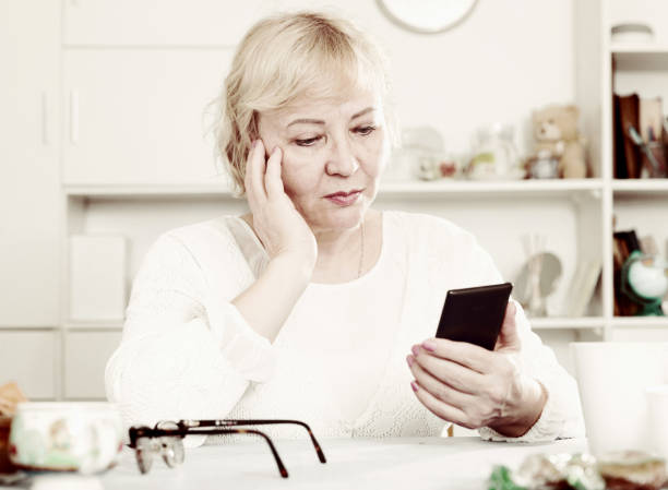 istock Mature woman with smartphone 902987568