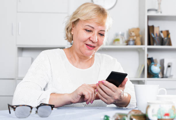 istock Mature woman with smartphone 902987574
