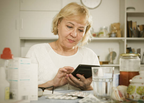 istock Mature woman with medicines and bills 902987576