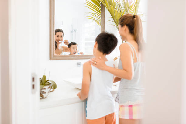 istock Mother and son brushing teeth in bathroom 902990774