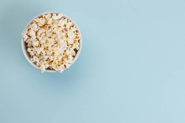 Popcorn Popcorn on blue background with copy space popcorn snack bowl isolated stock pictures, royalty-free photos & images