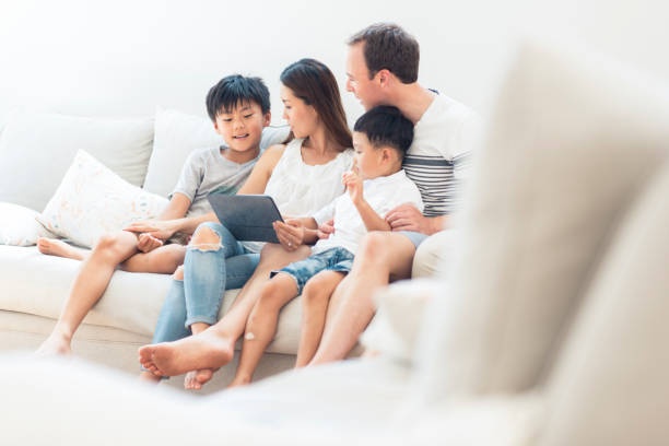 istock Family using digital tablet in living room 903002950